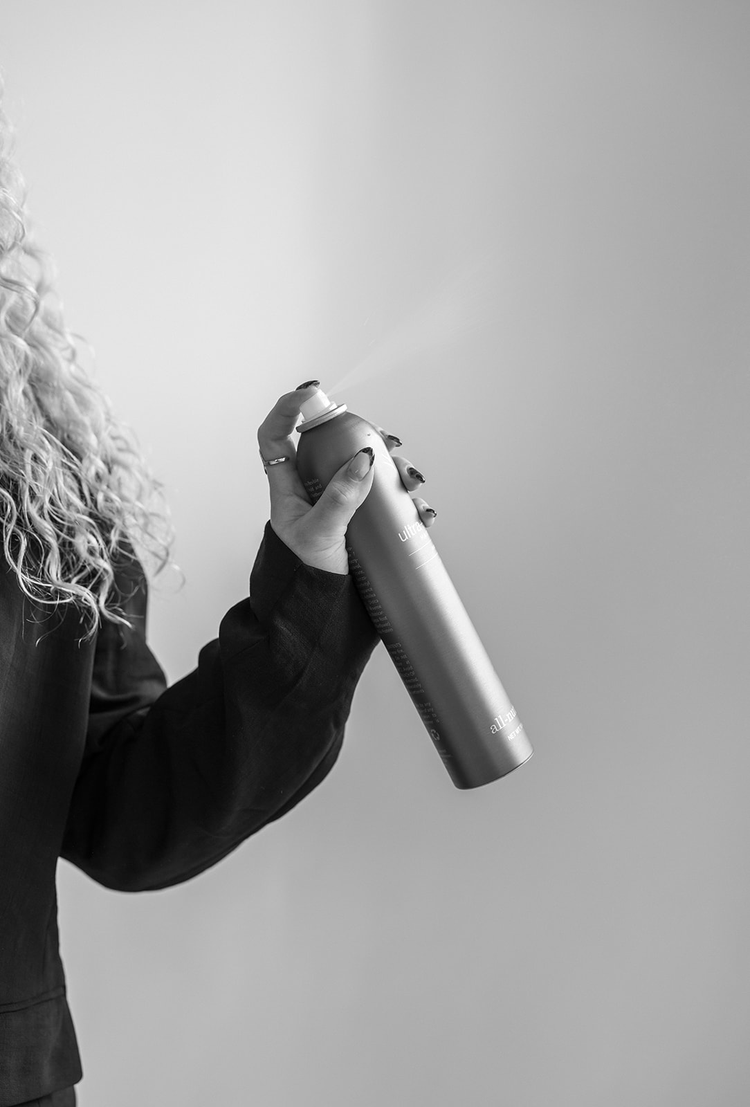 A Free To Be Me stylist finishing a look with hairspray